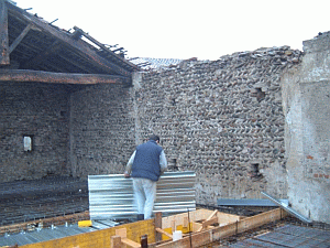 Lavori in corso di restauro del muro con sassi di fiume